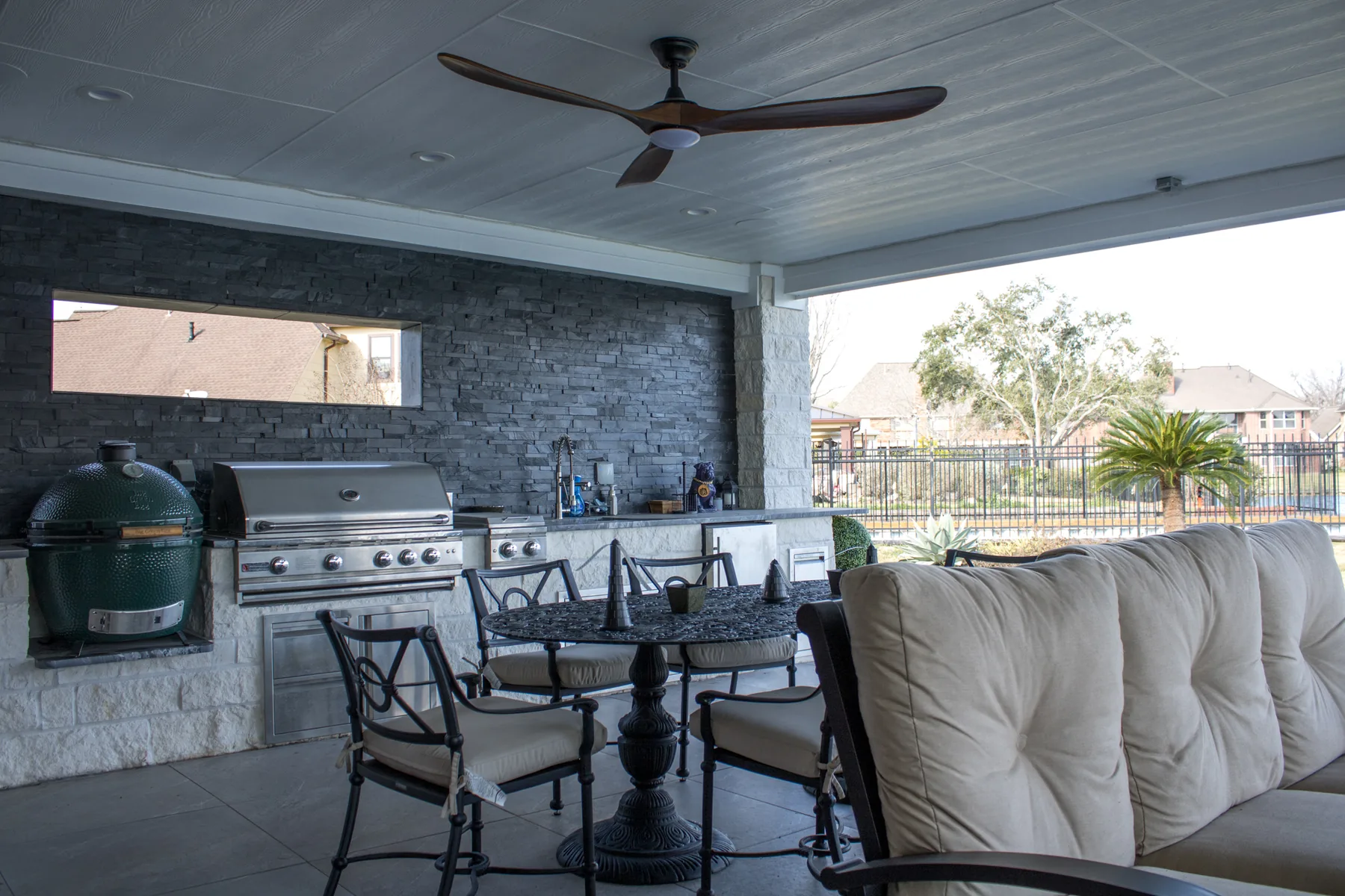 Stone outdoor-kitchen feature wall beneath the patio cover