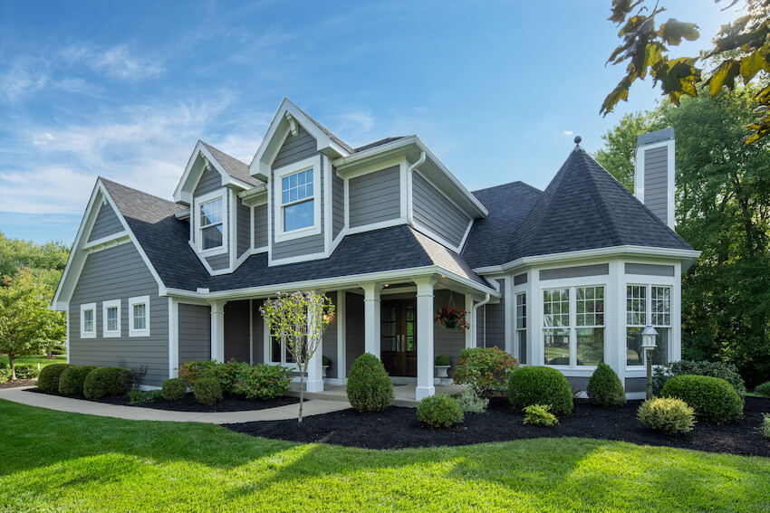 Aged Pewter home combining lap, panel and shingle siding profiles with white trim