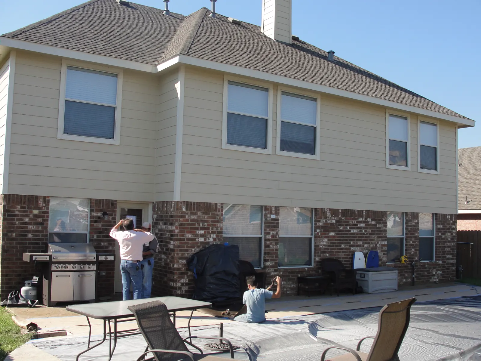Siding installation in progress on the rear of a two-story home