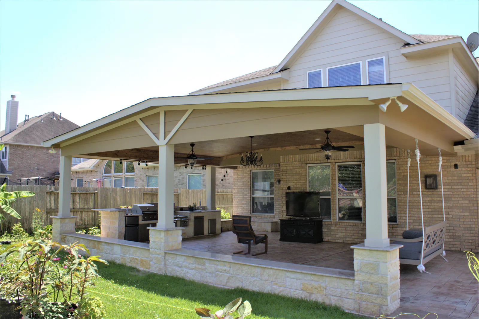 Gable-roof covered patio with an outdoor kitchen and ceiling fans